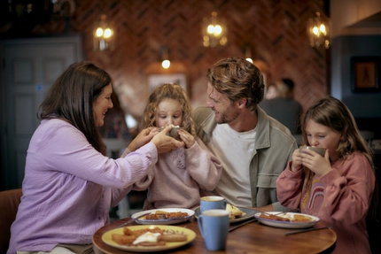 Family enjoying drinks together at a pub table.
