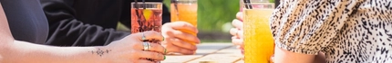 A mixed group of people sitting in a beer garden enjoying cocktails.