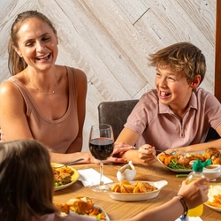 An image of a family enjoying a Sunday Roast and various drinks within the interior restaurant and seating area at a Hungry Horse venue.