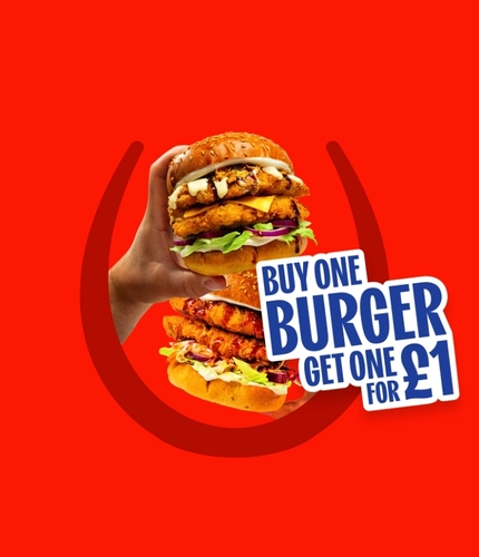 Promotional graphic reading “Buy One Burger, Get One for £1” alongside two crispy chicken burgers held in hands, topped with cheese, lettuce, red onion and sauce, on a red background with a horseshoe graphic. with cheese