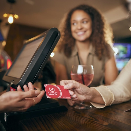 Pub team member serving drinks at the bar.