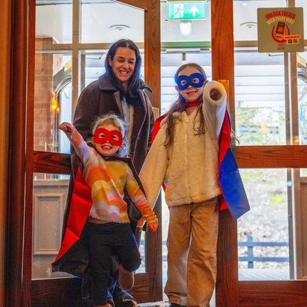 Two children dressed as  Superheros, doing s superhero pose in the interior of a Hungry Horse venue.